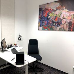 Ein Beratungsraum der Reichart-Filiale Dachau mit einem großen Wandbild. Vertrauen Sie auf unsere Erfahrung in der Hörgeräteversorgung.