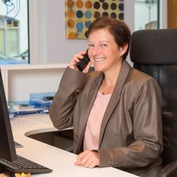 Freundliche Mitarbeiterin der Hörgeräte Reichart Filiale in Oberhaching, die telefonisch Kundenanfragen bearbeitet und Beratung zu Hörgeräten bietet.