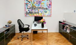 Hörgeräte Reichart Schwabing-West – einladendes Büro mit kreativem Wandgemälde, spezialisiert auf Hörakustik-Dienstleistungen und Hörtests.