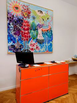 Hörgeräte Reichart Schwabing-West – moderner Empfangstresen mit kreativem Kunstwerk, einladend und professionell.