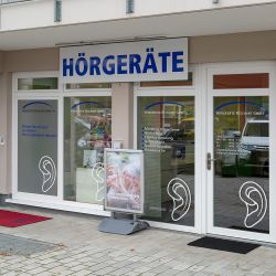 Außenansicht der Filiale Odelzhausen: Hörgeräte Reichart Geschäft in der Marktstraße 5, mit Beschriftungen und großem Schaufenster.