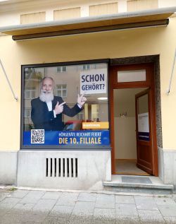 Filiale von Hörgeräte Reichart Schwabing-West – professioneller Hörakustik-Service in München, beworben mit einem auffälligen Schaufensterdesign.